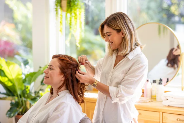 Coiffeuse chez une cliente, ambiance intime et professionnelle